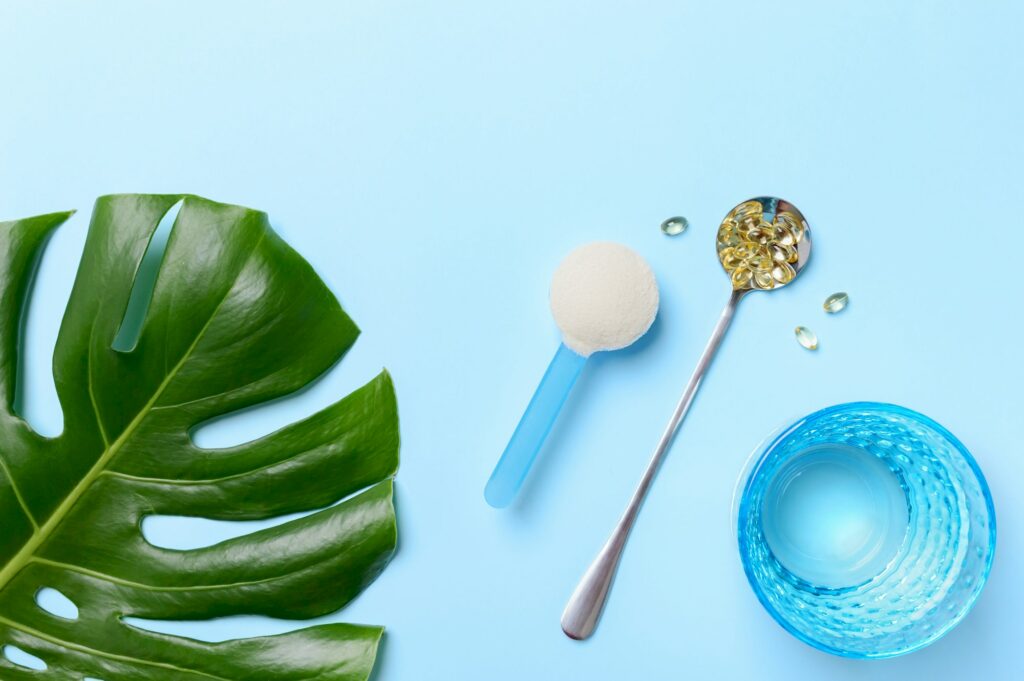 Collagen powder and capsules vitamin d-3 on a blue background